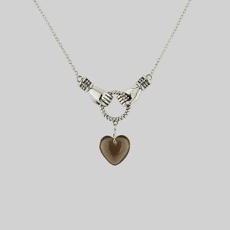 Subtle braid necklace-UNITE. Hand Grasping Smoke-Black Glass Heart Necklace - Silver